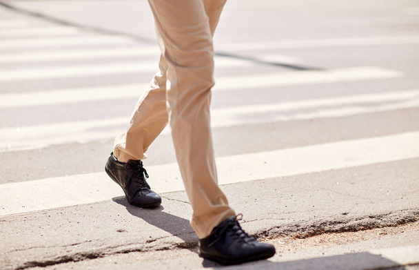 senior man walking along city crosswalk - Фото, зображення