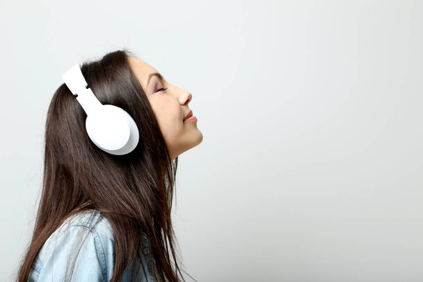 Young beautiful woman listening music with headphones - Fotó, kép