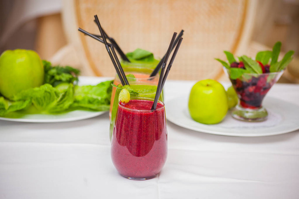 Red and green healthy smoothies with fresh ingredients on table. - Photo, Image