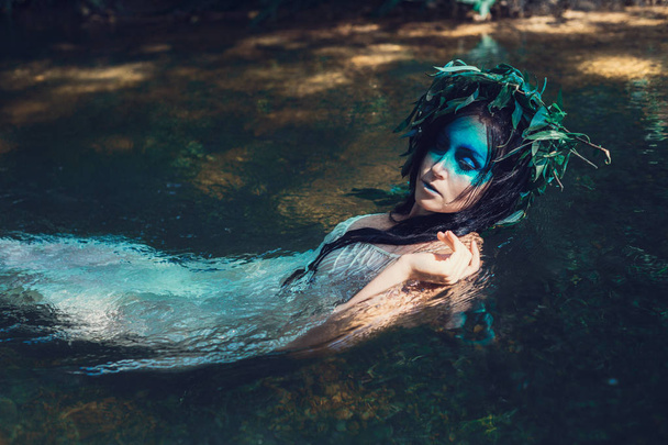 женщина с венком, лежащим в воде
 - Фото, изображение