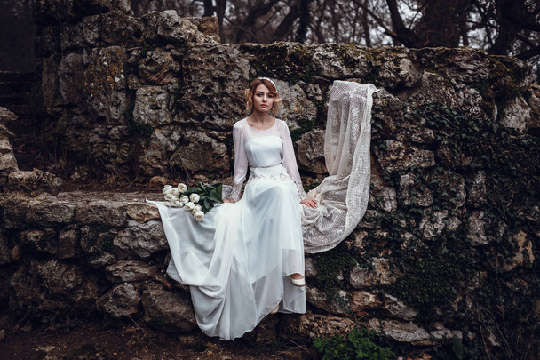 blonde vrouw in lange witte jurk - Foto, afbeelding