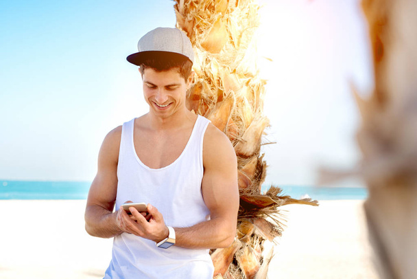 hombre usando teléfono inteligente en la playa
 - Foto, Imagen