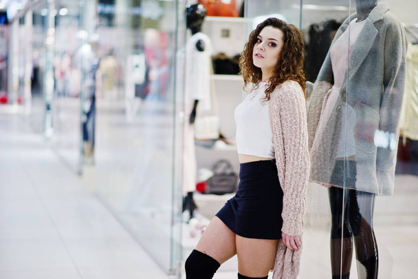 Young curly model girl posed on mini skirt at large shopping cen - Valokuva, kuva
