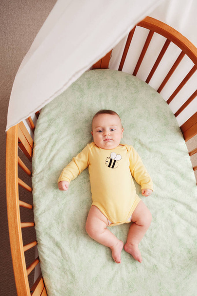 μωρό νεογέννητο σε κίτρινο onesie ψέματα - Φωτογραφία, εικόνα