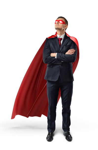 A businessman in an official suit and red cape with hands crossed and looking up. - Foto, Bild