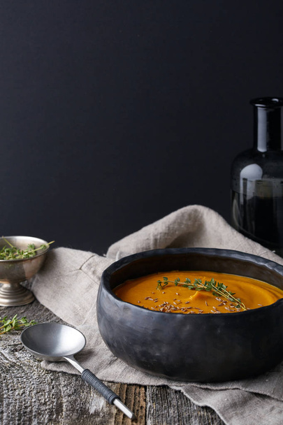 тыквенный крем-суп в темной посуде
 - Фото, изображение