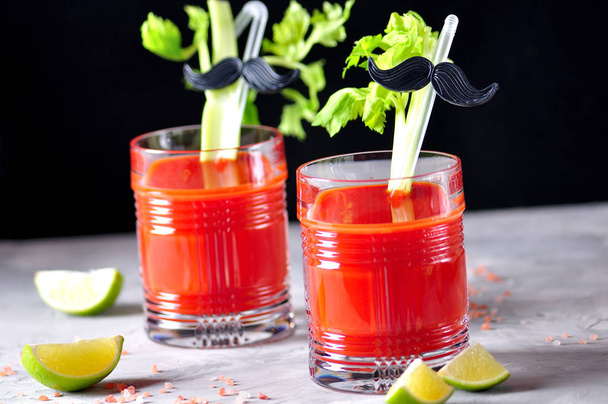 Traditional Bloody Mary cocktail with celery stick, lime and pink salt. - Photo, Image