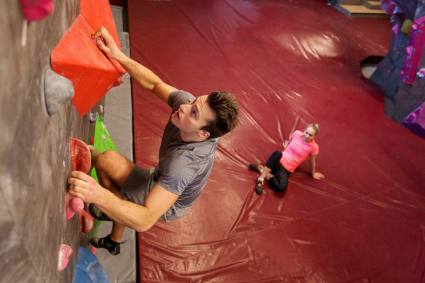 man and woman exercising at indoor climbing gym - Fotó, kép