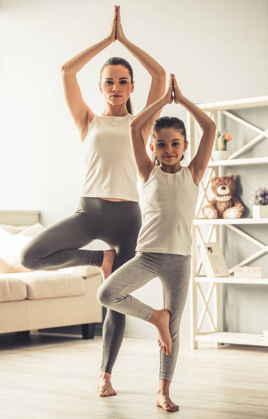 Mom and daughter doing yoga - 写真・画像