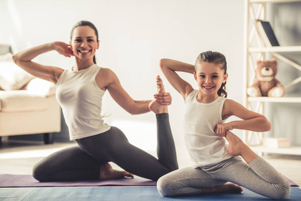 Mom and daughter doing yoga - Foto, afbeelding