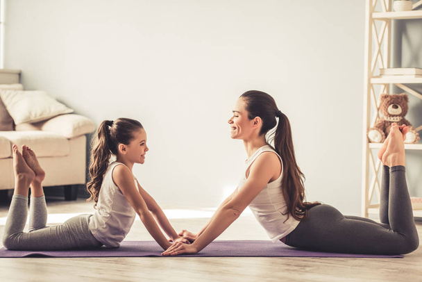 Mom and daughter doing yoga - Foto, afbeelding