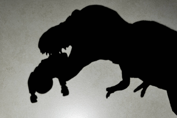 тень тираннозавра, кусающего тело на стене, закрывает логотип или торговую марку
 - Фото, изображение
