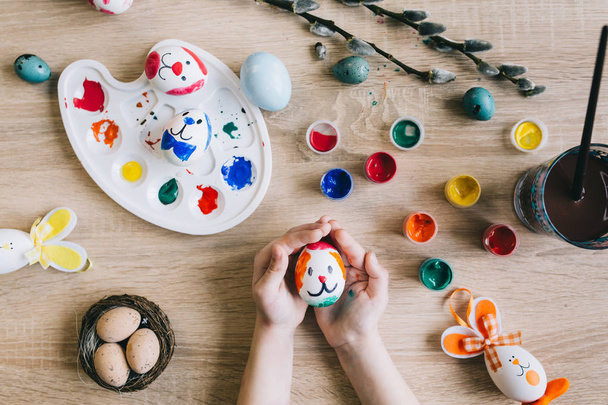 Маленькі руки малюють великодні яйця
 - Фото, зображення