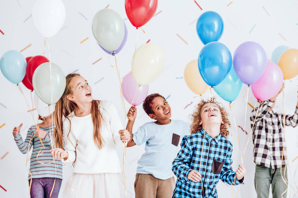 Kids dancing with balloons - 写真・画像