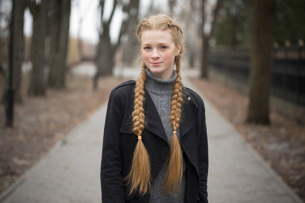 Red-haired girl with braids spring in nature. - Valokuva, kuva