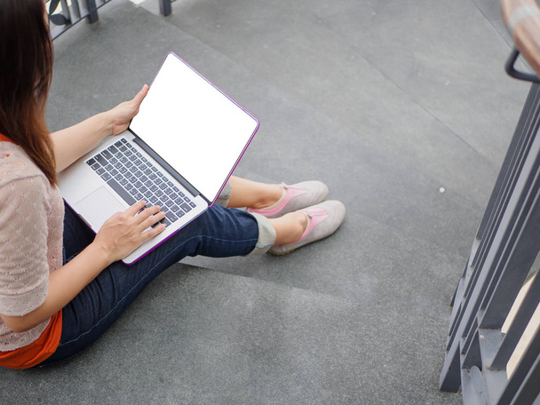 Jolie jeune femme utilisant un ordinateur portable. Femme travaillant sur un ordinateur portable dans un café extérieur
. - Photo, image