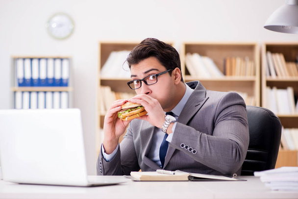 Πεινασμένος αστείος επιχειρηματίας τρώει σάντουιτς με πρόχειρο φαγητό - Φωτογραφία, εικόνα