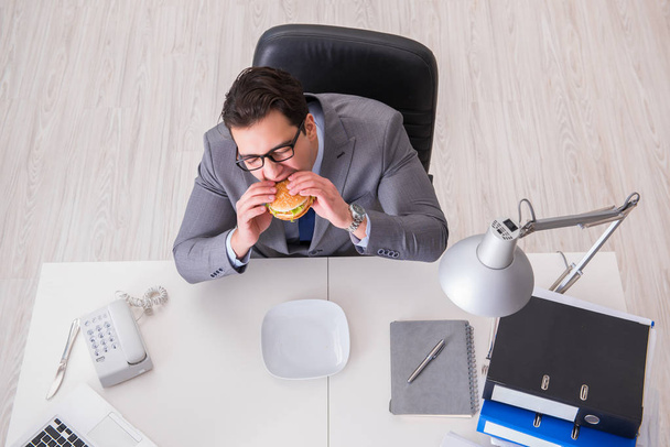 Hungriger, lustiger Geschäftsmann isst Junkfood-Sandwich - Foto, Bild