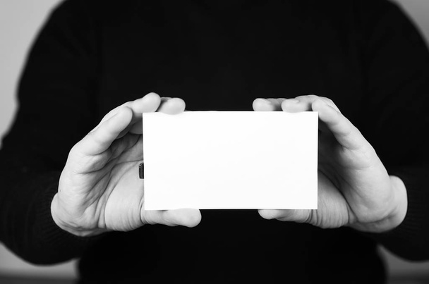 piccolo pezzo di carta bianco nella sua mano uomo monocromatico - Foto, immagini