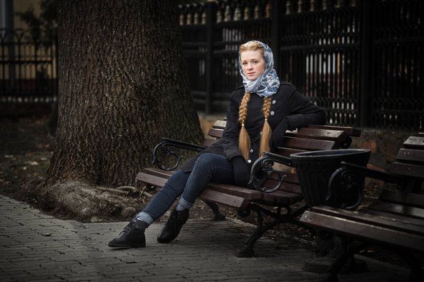 Krásná rusovlasá dívka sedí na lavičce - Fotografie, Obrázek