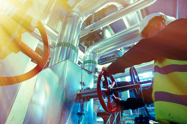 industrial factory worker turning red wheel of valve - Фото, зображення