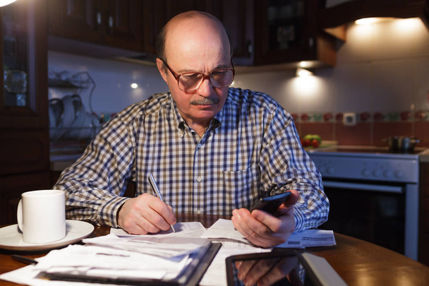 A man tiredly considers the family budget - Photo, Image