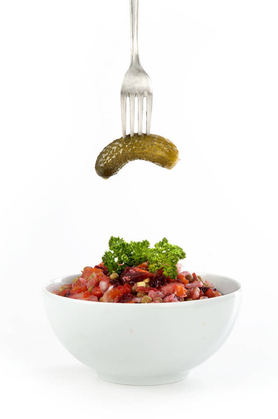 Orosz cékla saláta uborka dresszinggel fehér lemez a kockás szalvéta fehér alapon - Fotó, kép