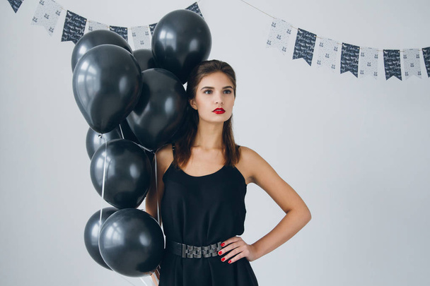 Girl in a black dress with black balloons - Fotografie, Obrázek