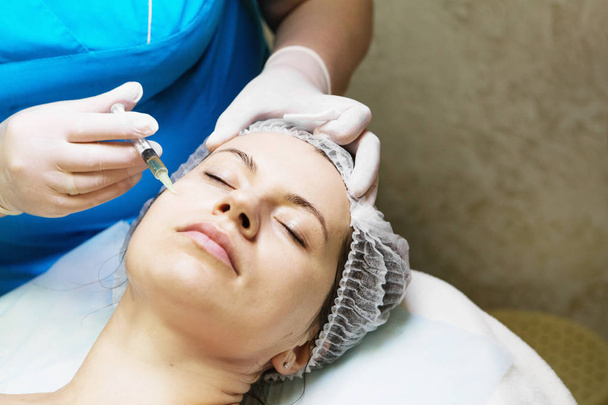 Kosmetologi suorittaa neula mesoterapia hoito naisen fa
 - Valokuva, kuva