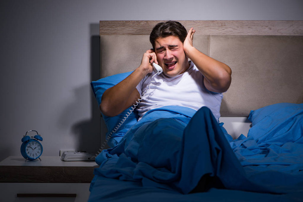 Mladý muž zápasí s hlukem v posteli - Fotografie, Obrázek