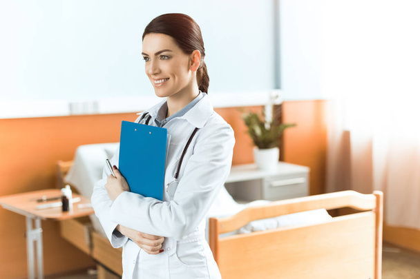 Young woman doctor with clipboard - Foto, imagen