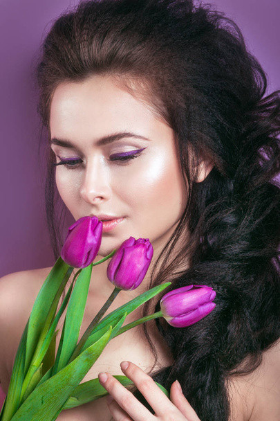 Portrait of romantic young woman with pink flower looking at camera  - Foto, afbeelding