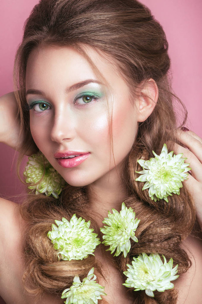 Portret van romantische jonge vrouw met groene bloem en make-up camera kijken . - Foto, afbeelding