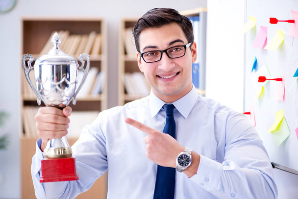 Mladý podnikatel dostává pohár s odměnami v úřadu - Fotografie, Obrázek