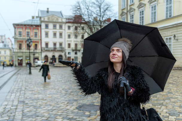 glückliches Mädchen mit Regenschirm auf der Straße im Regen - Foto, Bild