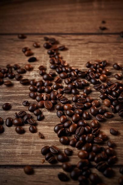 Black coffee beans on a wooden table - Photo, Image