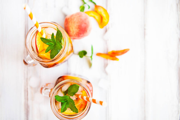 Homemade lemonade with ripe  peaches and fresh mint. Fresh peach - Foto, afbeelding