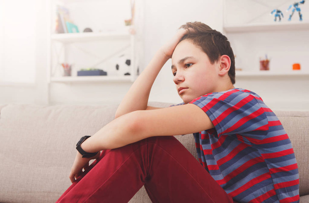entediado infeliz adolescente menino sentado em casa
 - Foto, Imagem