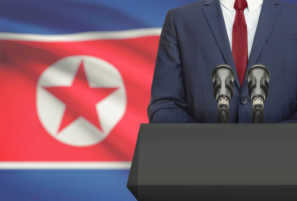 Üzletember és politikus így beszéd mögött a szószék, nemzeti zászló, a háttér - Észak-Korea - Fotó, kép