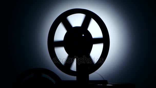 Orsó film projektor tárcsa film. Sziluettjét egy sötét stúdióban - Felvétel, videó