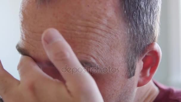 A man puts his contact lens into his eye - Záběry, video