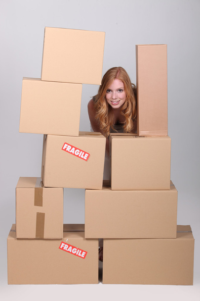Woman stood by pile of cardboard boxes - Photo, Image