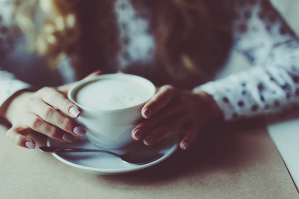 Close up εικόνα του γυναίκα τα χέρια που έτρεμαν καπουτσίνο στο café. - Φωτογραφία, εικόνα