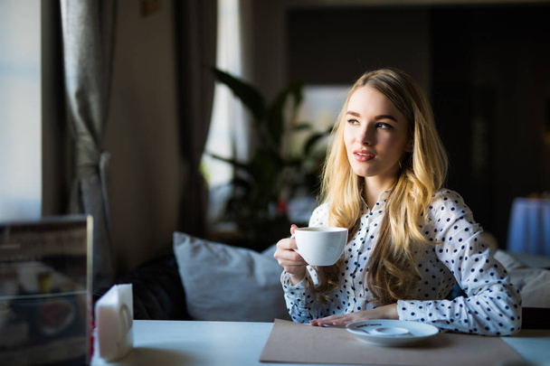 Mladá blond žena těší odpolední káva v kavárně - Fotografie, Obrázek