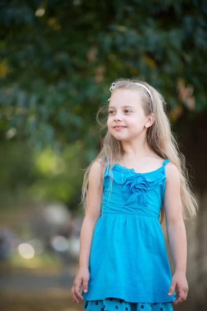 small baby girl with smiling face in blue dress outdoor - Fotografie, Obrázek