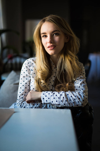 Beautiful young woman at a cafe - Фото, изображение