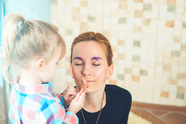 Roztomilá holčička dělá make-up na její atraktivní maminku. Tónovaný. - Fotografie, Obrázek
