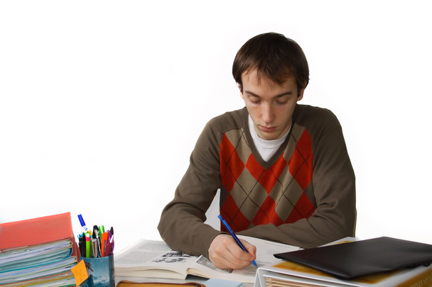 mannelijke student aan een tafel, schrijft - Foto, afbeelding