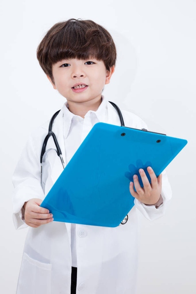 Asian Chinese little boy wearing doctor uniform with stethoscope - 写真・画像