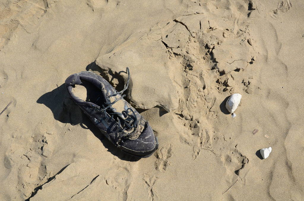 εγκαταλελειμμένο παπούτσι στην άμμο    - Φωτογραφία, εικόνα